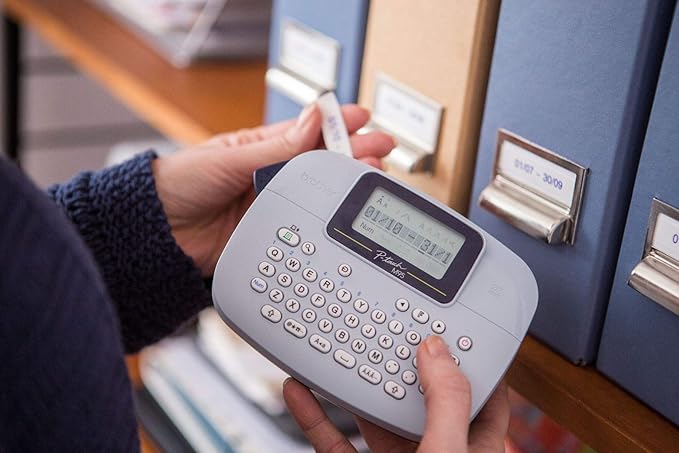Brother PT-M95 Label Maker, P-Touch Label Printer, Handheld, QWERTY Keyboard, Up to 12mm Labels, Includes Black on White Tape Cassette